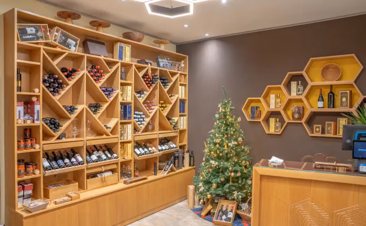Innenraum mit Holzregalen voller Wein und Honig